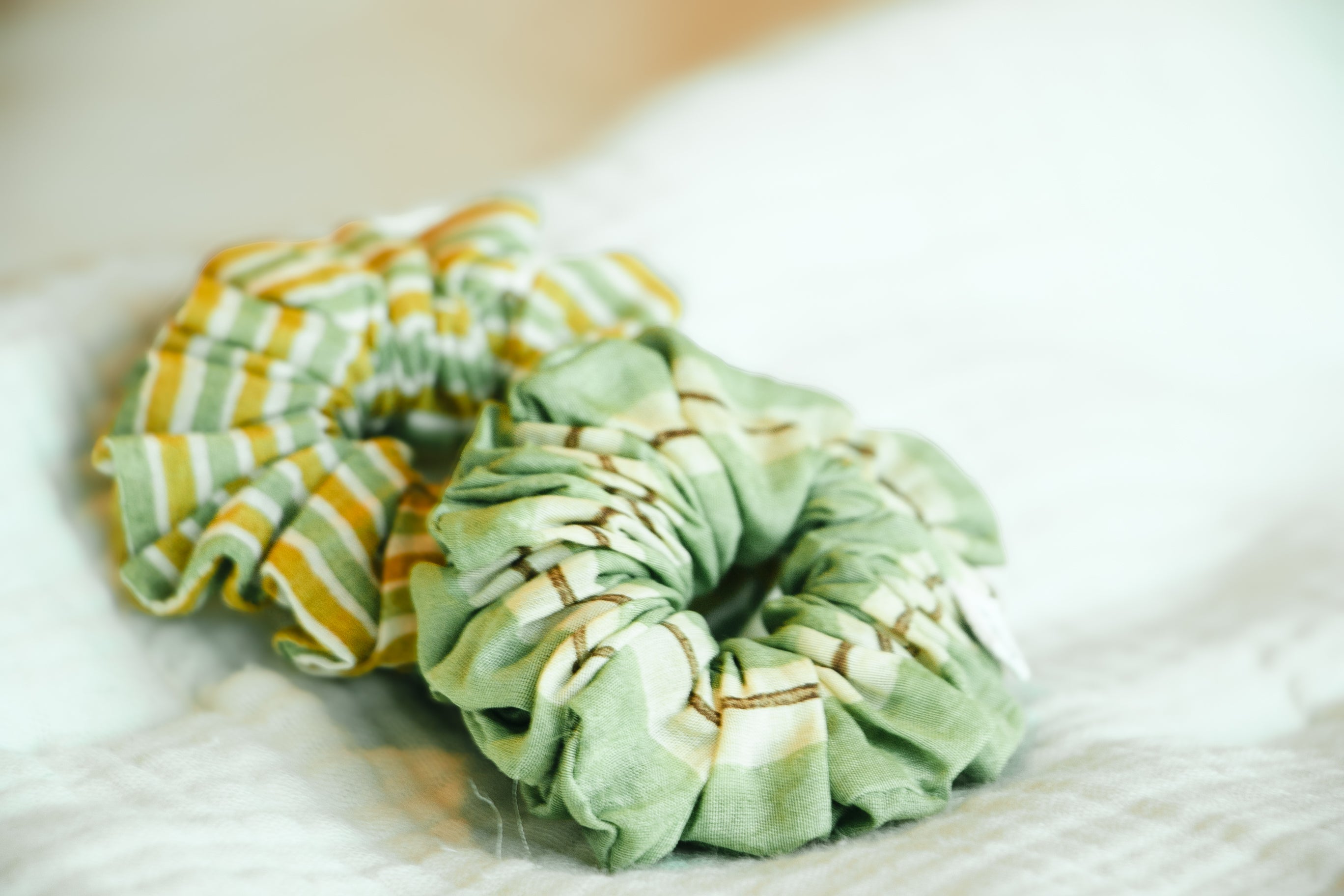 Two green scrunchies with striped patterns- Designed In USA, Made in India 