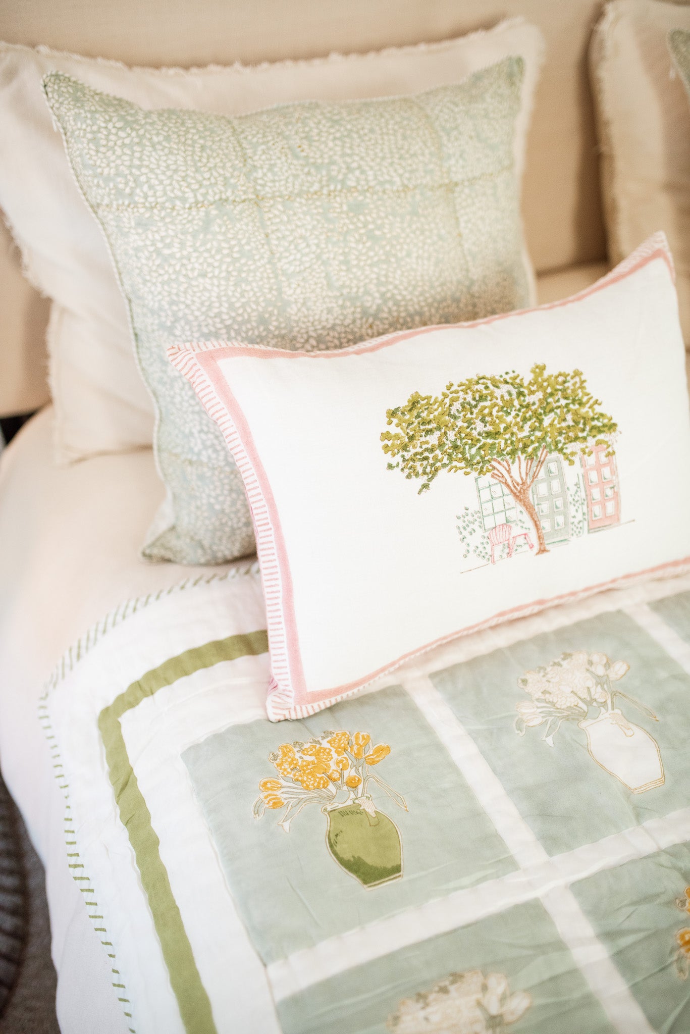 A pair of handcrafted block-printed throw pillows styled on a neutral linen sofa for a travel-inspired living room look