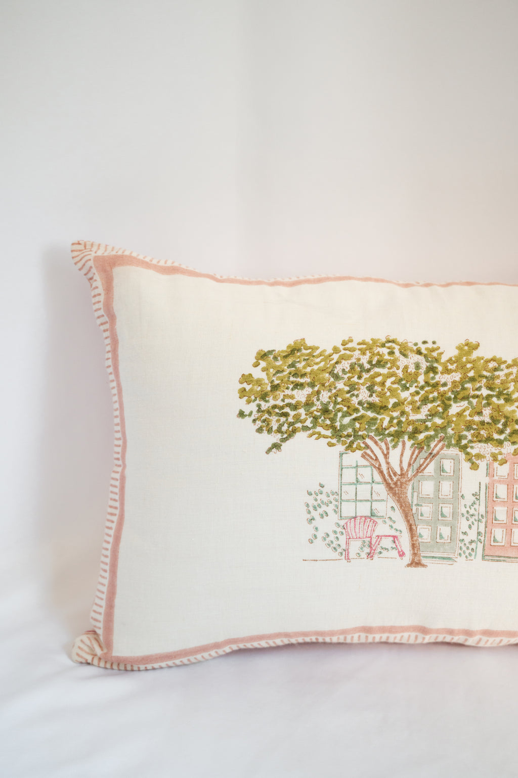 Close-up of a hand-carved wooden block being pressed onto a cotton cushion cover, showcasing the traditional Indian block printing process